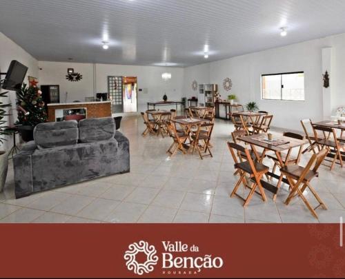 ein Wohnzimmer mit Tischen, Stühlen und einem Sofa in der Unterkunft Valle da Benção Pousada in Chapada dos Guimarães