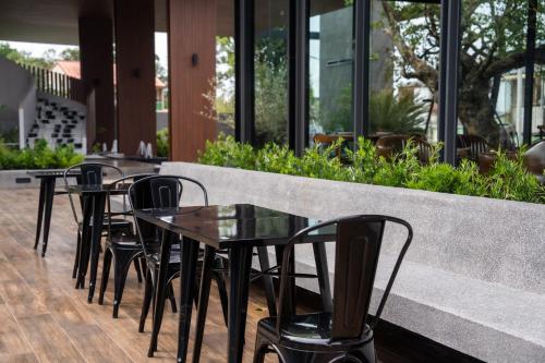 a row of tables and chairs in a restaurant at Richmann Resort Hotel Hatyai in Hat Yai