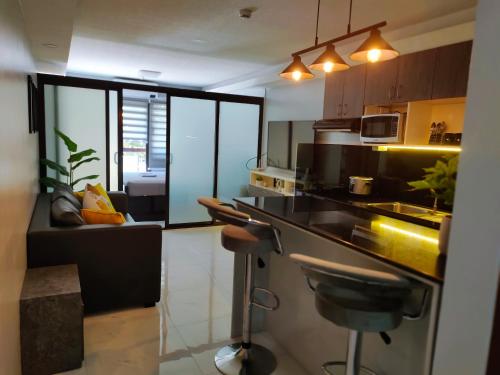 a kitchen with a bar counter and a living room at Aloha Hale One Oasis Cdo in Cagayan de Oro