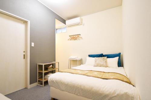 una camera da letto con un letto con testiera blu di Comfy Stay Sarusawaike a Nara