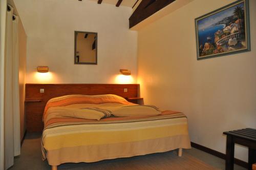 a bedroom with a bed and a mirror on the wall at La Cigalière in Le Beausset