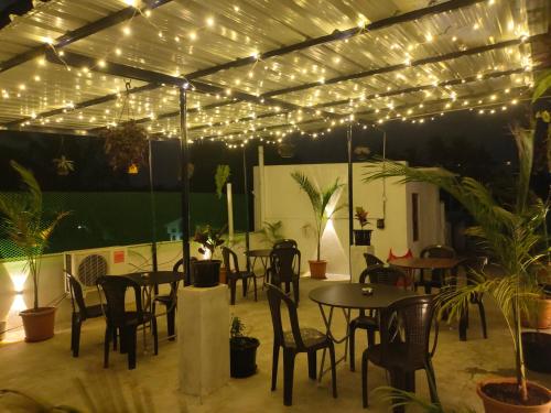 d'une terrasse avec des tables, des chaises et des lumières. dans l'établissement La Township Residency, à Pondichéry