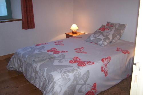 a bedroom with a bed with red butterflies on it at Domaine de Salomony in Marcols-les-Eaux