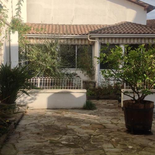 a house with a stone patio in front of it at Mirailh in Amou