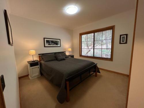 um quarto com uma cama grande e uma janela em The Blue Wren Lodge 111 em Halls Gap