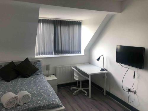 a bedroom with a bed and a desk with a computer at Newly refurbished studio, great location 8 studios in Nottingham
