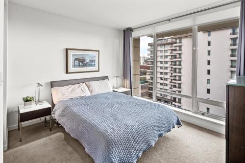 a bedroom with a bed and a large window at Falls Empress Suite by IRIS PROPERTIES! in Victoria