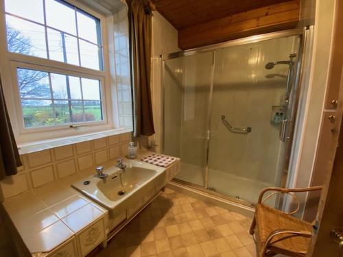 y baño con ducha y lavamanos. en lake District cottage en Bootle