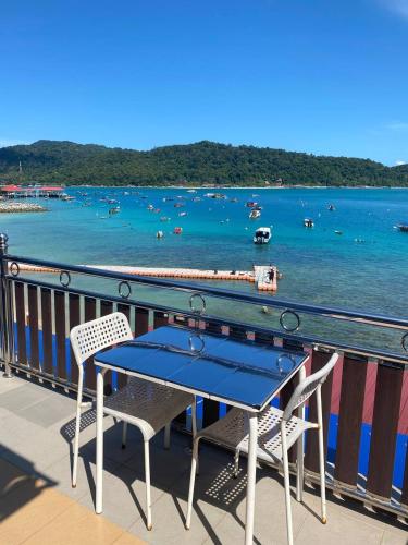 a table and chairs on a balcony overlooking a body of water at Perhentian Nemo Chalet in Perhentian Island
