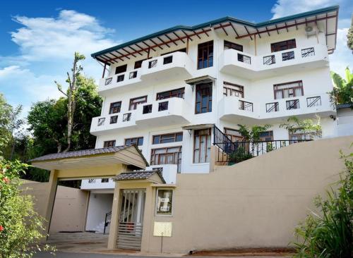 a large white building with a gate in front of it at SaRu Holiday Apartment - Upto 6 Guests in Kandy