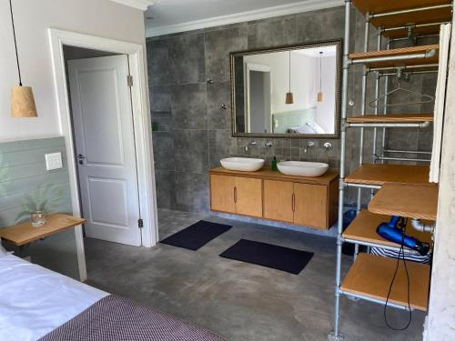 uma casa de banho com 2 lavatórios e um espelho em TAMO Guest Farm em Plettenberg Bay