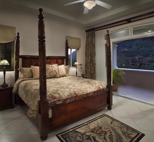 a bedroom with a canopy bed and a window at Stay In CR Los Sueños Condos in Jacó