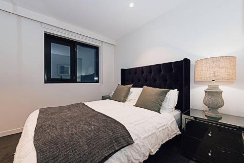 um quarto com uma cama grande e uma janela em Chic Urban Oasis em Melbourne