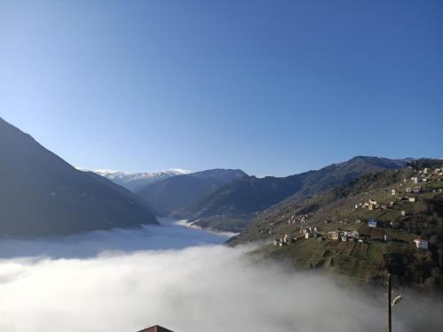 a view of a river in the mountains with clouds at Villa Pamuklu second floor only in Çaykara