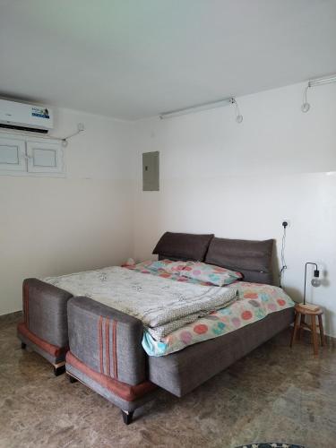 ein Bett in einem Zimmer neben einer Wand in der Unterkunft بيت المقصورة بولاية سناو 
