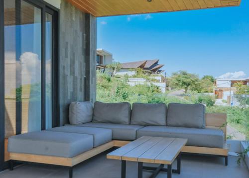 a couch and a coffee table on a patio at Truntum Boutique Mandalika in Kuta Lombok