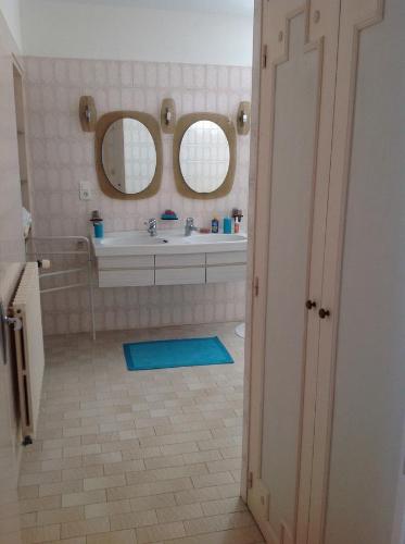 een badkamer met een wastafel en 2 spiegels bij Mirailh in Amou