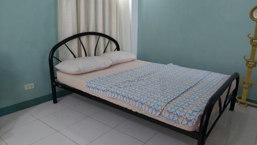 małe łóżko w pokoju z niebieską ścianą w obiekcie GGGO RESIDENCES, Studio 103, pet friendly w mieście Sorsogon