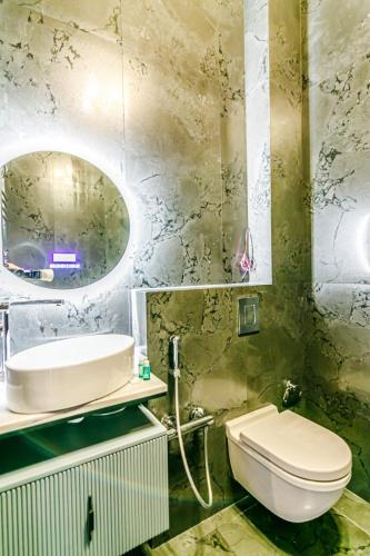 a bathroom with a toilet and a sink and a mirror at Baku K NightsBridge Residance in Baku