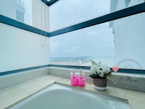 eine Badewanne im Bad mit Fenster in der Unterkunft SilverScape 4px Seaview Bathtub TVBox Games in Malakka