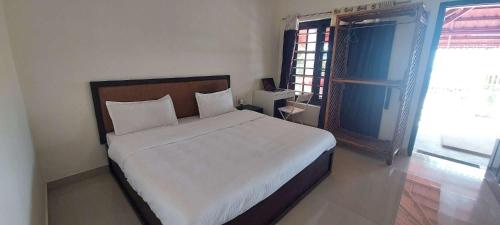 1 dormitorio con 1 cama blanca grande en una habitación en Happy Seas Beach Villa en Alleppey