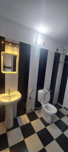 a bathroom with a toilet and a sink at Happy Seas Beach Villa in Alleppey