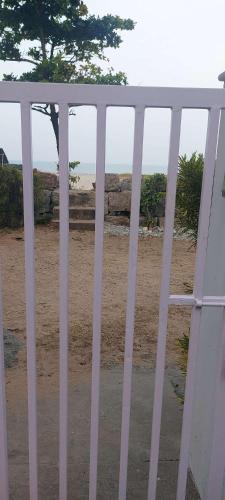 a white gate with a view of the beach at Happy Seas Beach Villa in Alleppey