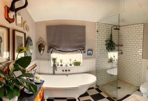 a bathroom with a tub and a glass shower at Oude Pastorie in Nieu-Bethesda