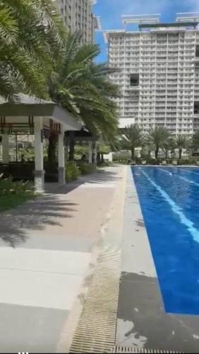 Una piscina con palmeras al lado de un edificio. en Eagle's Nest - 2BR Furnished with Fast Internet and Netflix, en Davao City