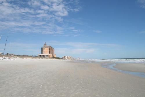 
a beach with a beach house and a lighthouse at Cabana Shores Hotel in Myrtle Beach
