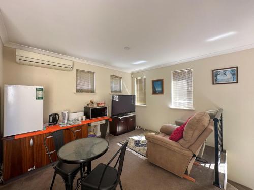 een woonkamer met een bank en een tafel bij Joondalup Guest House in Perth