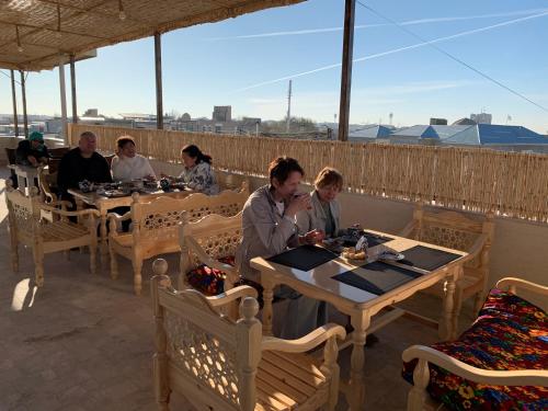 um grupo de pessoas sentadas em mesas em um restaurante em Hotel Saidkasim with a Terrace em Bukhara