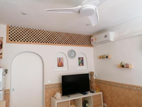 Una sala de estar con un televisor de pantalla plana en una pared. en la siesta 23D, en Benidorm