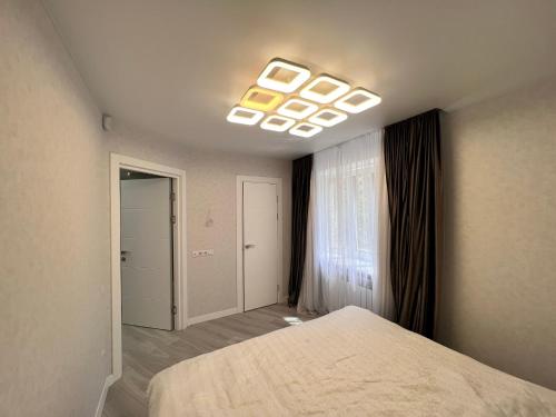 a bedroom with a large bed and a window at Modern Gagarina Avenue in Dnipro