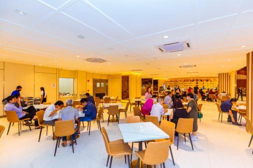 a group of people sitting at tables in a restaurant at Dynasty Casino Hotel in Bavet