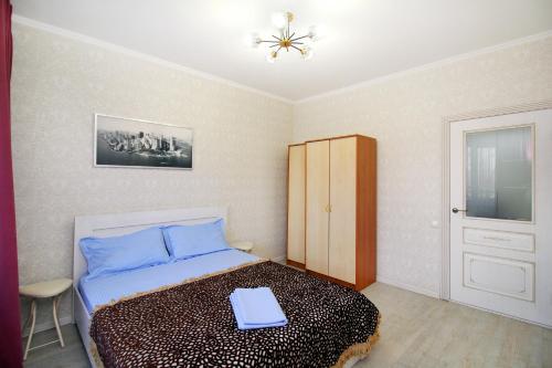 a bedroom with a bed with blue sheets and a cabinet at ЖК Радужный берег РБ 14 in Turksib