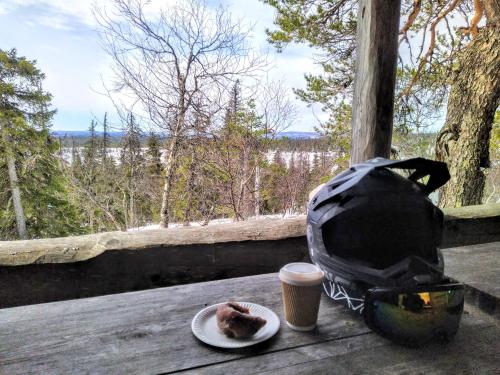 a table with a bag and a piece of cake and a cup of coffee at Isokelo Log Apartments in Salla