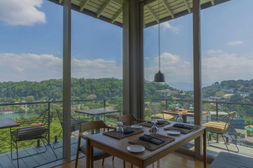 una stanza con tavolo e sedie e una grande finestra di Rivora Heights a Kandy