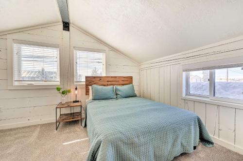 a bedroom with a bed and two windows at Centrally Located Pinedale Vacation Rental! in Pinedale