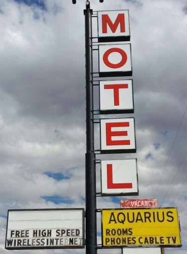 a sign for a store with several signs on it at Aquarius Inn in Bicknell