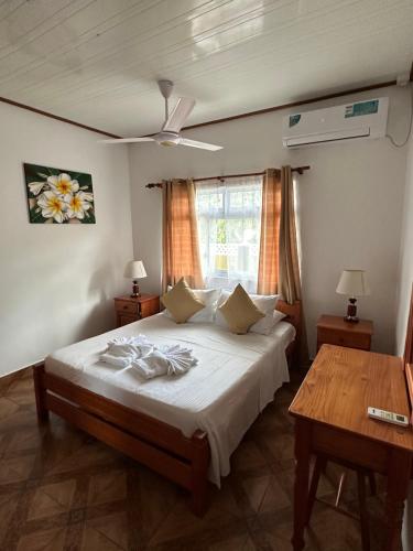 a bedroom with a large bed and a table at Happy stay villa in Grand'Anse Praslin