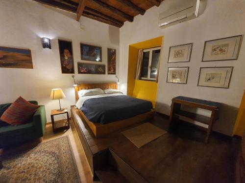 ローマにあるAppartamenti Gardeniaのベッドルーム(ベッド1台、緑のソファ付)