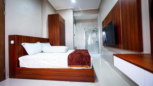 Dormitorio pequeño con cama y ducha en Omah Tamansiswa, en Timuran
