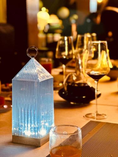 a table with glasses of wine and a bottle of wine at Meilin International Hotel in Kampala