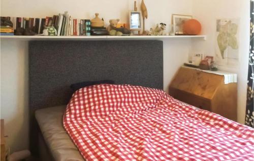 a bed with a red and white blanket on it at Stunning Home In Tby With Kitchen in Täby