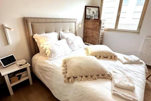 een slaapkamer met een groot wit bed en een raam bij Le Touquet Beach, Front de Mer in Le Touquet-Paris-Plage