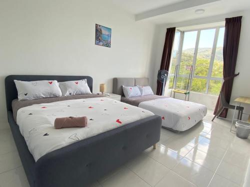 - une chambre avec 2 lits et une grande fenêtre dans l'établissement Aufa Homestaymuslim's at Emerald Avenue Brinchang, à Brinchang