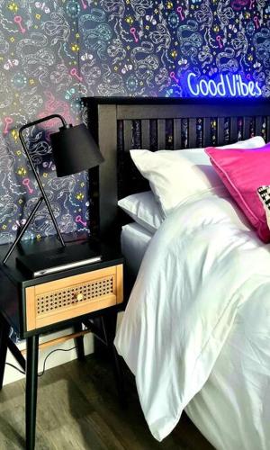 ein Schlafzimmer mit einem Bett und einem Nachttisch mit einer Lampe in der Unterkunft Boutique Annexe Close To Norwich City & Airport in Horsham St Faith