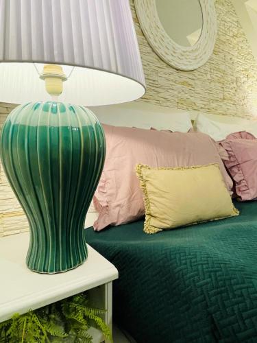a green vase sitting on a table next to a bed at Hotel Marcincak*** in Mikulov