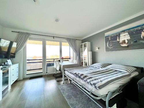 1 dormitorio con cama, escritorio y ventana en Ostsee-Fördeblick en Laboe